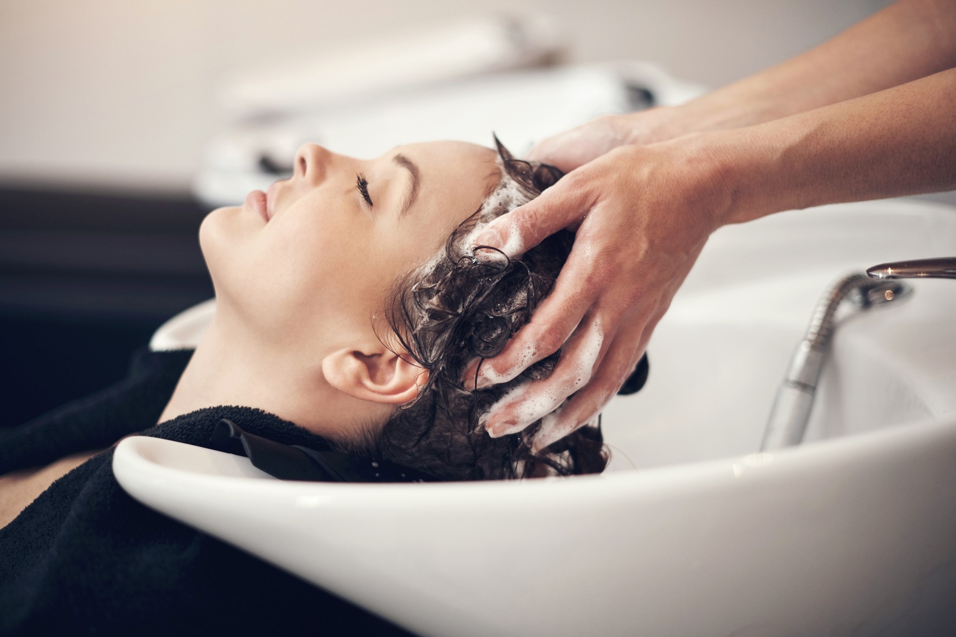 Shot of a beautiful young woman getting her hair washed at the salon